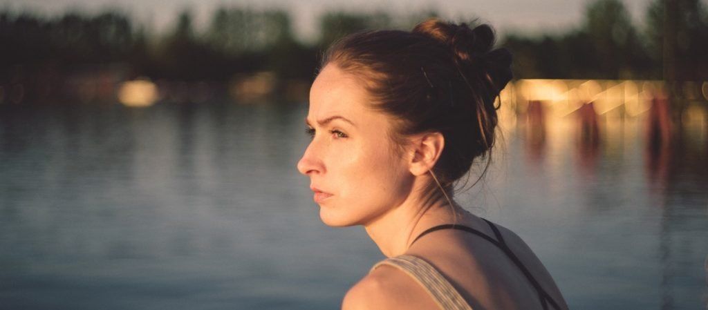 Woman sitting on dock on the water